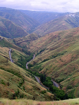 [Looking down in the valley at the ribbon of roadway winding back and forth.]